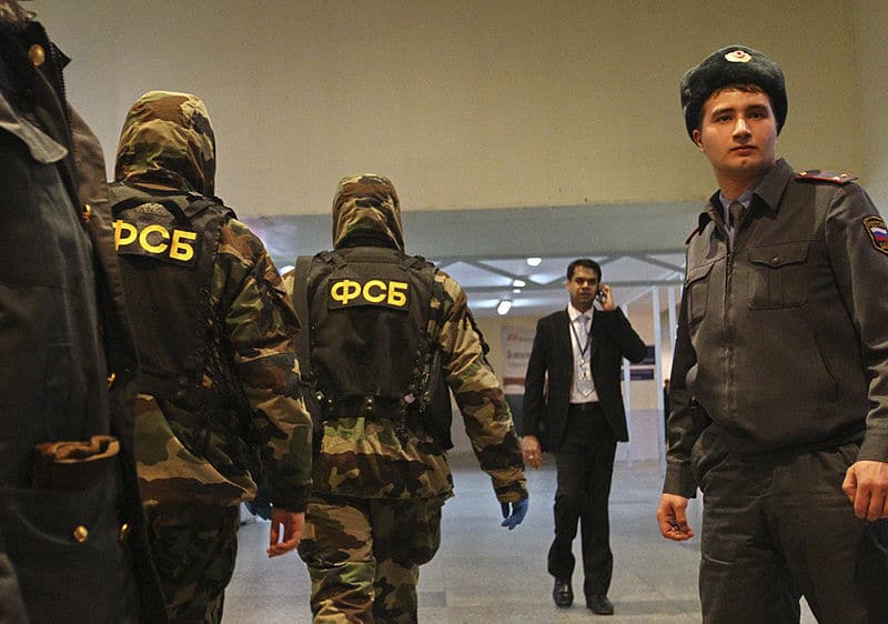 Russian FSB officers walk through a room.